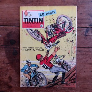 May include: Vintage comic book cover featuring a motorcycle race scene with riders in action. The cover has the title "TINTIN" and the text "40 pages". The comic book is on a wooden surface.