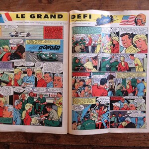 May include: A vintage comic book spread, showcasing vibrant illustrations of a car race. The title "LE GRAND D&Eacute;FI" is displayed at the top. Panels depict racers, cars, and speech bubbles, creating a retro aesthetic.