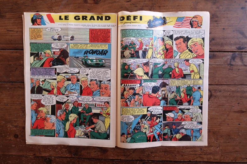 May include: A vintage comic book spread, showcasing vibrant illustrations of a car race. The title "LE GRAND D&Eacute;FI" is displayed at the top. Panels depict racers, cars, and speech bubbles, creating a retro aesthetic.