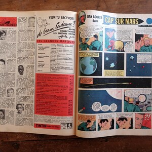 May include: Open vintage comic book pages with French text and illustrations. The right page features a space-themed comic strip titled "CAP SUR MARS." The left page has text and small portraits. The book is open on a wooden surface.