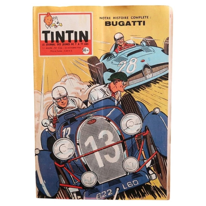 May include: A vintage Tintin comic book cover featuring a yellow background with the title TINTIN and the text NOTRE HISTOIRE COMPLETE: BUGATTI. The illustration depicts two blue race cars with drivers in helmets, one numbered 13 and one numbered 28.
