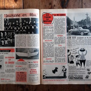May include: Open newspaper pages with vintage articles and illustrations. Headlines include "Jeunesse en bleu" and "Le Tour du Monde." Images feature a parade, a car, and cartoon figures. The pages are on a wooden surface.