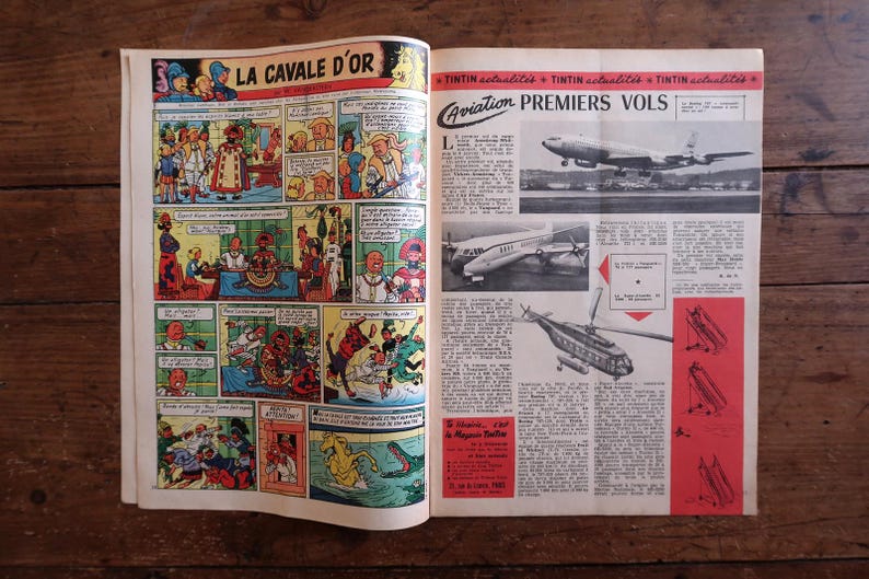 May include: Open vintage comic book pages with colorful illustrations. One page features a comic strip titled "LA CAVALE D'OR". The other page has aviation-themed articles with images of airplanes and helicopters. The pages are on a wooden surface.