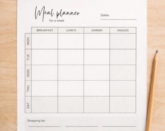 May include: A white weekly meal planner with a grid for each day of the week, including breakfast, lunch, dinner, and snacks. The planner has a shopping list section and the text "Weekly Meal Planner" at the top. A pencil rests on the right.