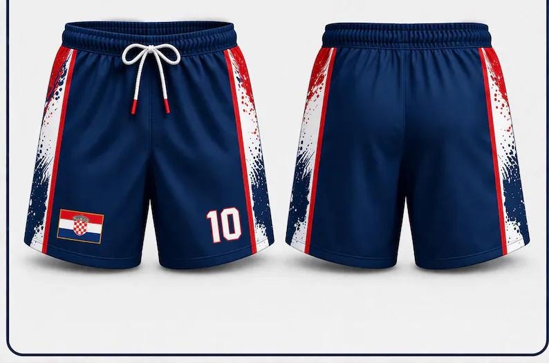Pu&ograve; includere: Pantaloncini sportivi blu navy con coulisse bianca e dettagli rossi. I pantaloncini presentano una toppa con la bandiera croata e il numero 10 in bianco. Il design include un motivo a spruzzi bianco sui lati.