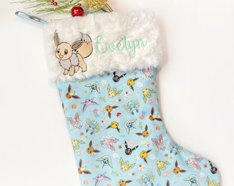 Personalized Christmas stocking made from blue Pokémon fabric featuring Eevee evolution, fully lined Cotton with fur cuff, embroidered gamer