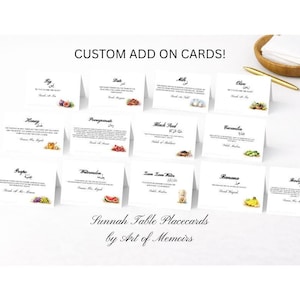 May include: A collection of white place cards featuring watercolour illustrations of various foods and fruits, such as figs, dates, and olives. Each card includes Arabic script and English translations. The cards are labelled "Custom Add On Cards!" and "Sunnah Table Placecards by Art of Memoirs."