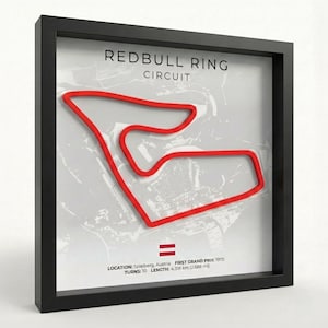 Può includere: Opera d'arte incorniciata con la mappa del circuito Red Bull Ring in rosso su sfondo grigio. La cornice nera circonda la mappa, con testo che indica la località di Spielberg, Austria, e il primo Gran Premio nel 1970. La lunghezza della pista è di 4,318 km.