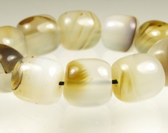 May include: A strand of white agate beads with brown and yellow markings. The beads are strung on a black cord.