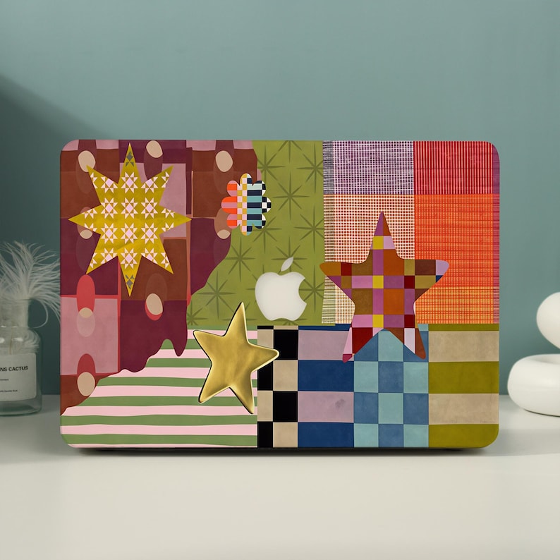 May include: A laptop hard shell case featuring a multi-colored patchwork design with various patterns including stripes, checkers, and star shapes. The surface displays a yellow star, a multi-colored star, and a white Apple logo in the center.