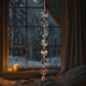 May include: A decorative hanging ornament featuring seven circular frames, each with a butterfly design. The butterflies are adorned with colorful crystals in shades of purple, blue, green, yellow, brown, and red. The ornament hangs from a delicate gold chain.
