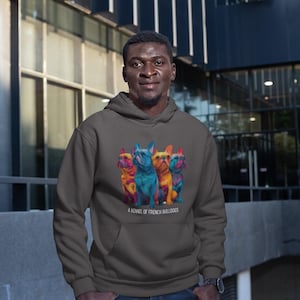 May include: A dark gray hoodie featuring a colorful graphic of four French Bulldogs. The dogs are depicted in vibrant hues of blue, orange, yellow, and red. The text "A KENNEL OF FRENCH BULLDOGS" is printed below the graphic.