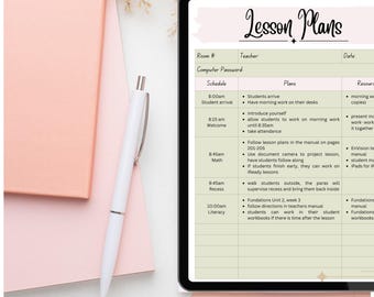 以下が含まれることがあります： デジタルタブレットには、「Lesson Plans」というタイトルの授業計画が表示され、スケジュール、計画、リソースが示されています。白いペン、ピンクのノート、ローズゴールドのペーパークリップが白い表面に配置されています。乾燥した花の茎が装飾的なタッチを加えています。