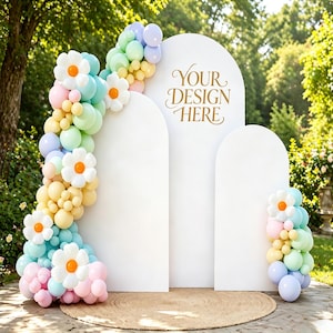 Può includere: Uno sfondo ad arco bianco con la scritta "YOUR DESIGN HERE" in oro. Lo sfondo è decorato con una ghirlanda di palloncini colorati in colori pastello e grandi accenti di margherite. Un tappeto rotondo e intrecciato si trova alla base.