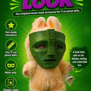 May include: A plush doll wearing a green mask, with the text "MASK-INSPIRED LOOK". The doll is light orange with yellow feet and ears. The mask is designed to fit 17 cm plush dolls. The text says "Fan-made accessory" and "Display ready".