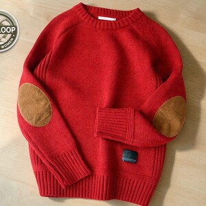 Könnte beinhalten: Ein roter Pullover mit braunen Ellbogenpatches. Der Pullover hat einen Rundhalsausschnitt, gerippte Bündchen und einen kleinen Aufnäher unten. Das Cozyloop-Logo befindet sich oben links. Der Pullover ist aus weichem Material.