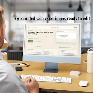 May include: A person working on a computer with the text "A grounded web experience, ready to edit" displayed on the screen. The computer is on a wooden desk with a keyboard, mouse, and water bottle.