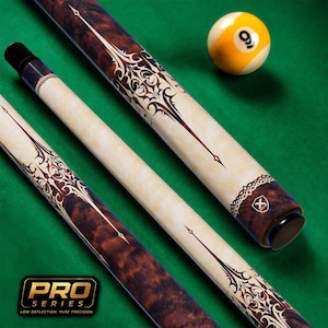 Könnte beinhalten: Ein zweiteiliges Billard-Queue mit einem cremefarbenen Schaft und einem Griff aus dunkelbraunem Maserholz mit komplexen schwarzen Filigranmustern. Das Queue hat eine schwarze Endkappe mit Logo sowie eine gelb-weiße Neuner-Billardkugel daneben.