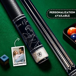 May include: Black and silver pool cue with a personalized design. The cue features a black shaft with silver accents and a white base. The design includes a couple embracing and the text "Olivia & Dad". The image also includes the text "Personalization Available" and "Your Photo".