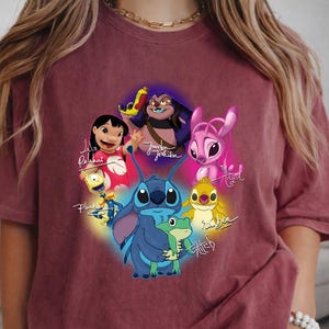 Op de afbeelding: Bordeauxkleurig T-shirt met een kleurrijke afbeelding van personages uit de animatiefilm Lilo & Stitch. Het ontwerp bevat Stitch, Lilo en andere personages, met hun namen in cursief geschreven. Het shirt is gemaakt van een zacht materiaal.