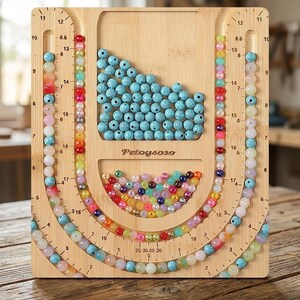 May include: A light-colored wooden bead board with the brand name Petoysoso engraved in the center. The board features U-shaped channels with printed inch measurements, filled with various colorful beads, and two recessed storage compartments.