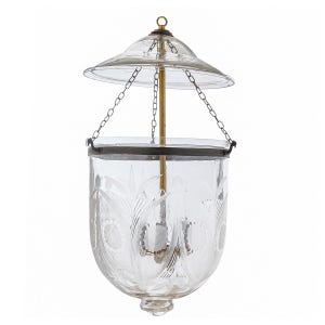 May include: Clear glass hanging lantern with etched floral designs. The lantern has a domed top and a cylindrical body, suspended by chains. A brass rod runs through the center. The lantern is designed to hold a light source.
