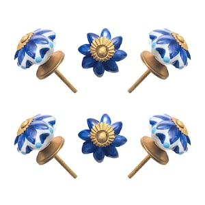 May include: Six decorative cabinet knobs. Three knobs feature a blue and white floral design with gold accents, and three have a solid blue flower design with gold centers. Each knob has a gold-toned base and screw.