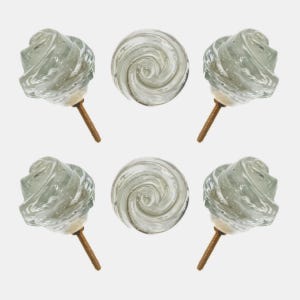 May include: Six clear glass cabinet knobs. Two knobs are round with a swirl design, and four are rose-shaped. Each knob has a brass screw for installation. The knobs are set against a white background.