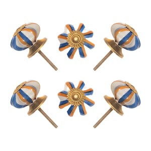 May include: Six decorative cabinet knobs. The knobs have a white, blue, and orange striped design with a gold-colored base and screw. Two knobs are flower-shaped, and four are rounded.