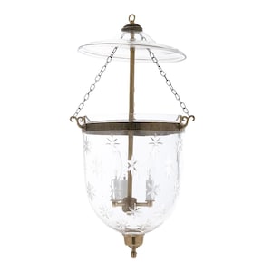 May include: Clear glass hanging lantern with a starburst pattern. The lantern has a brass-colored metal frame, chain, and central support. A clear glass top and bottom complete the design. The lantern is designed to hold two light bulbs.