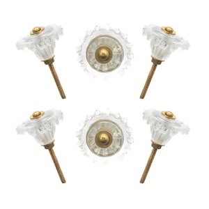 May include: Six clear glass cabinet knobs with a flower-like design. Each knob has a gold-colored metal base and a threaded brass screw. The knobs are arranged in a square pattern against a white background.