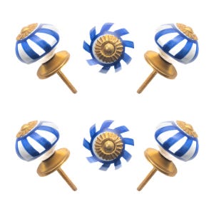 May include: Set of six decorative cabinet knobs. The knobs feature a white and blue striped design with a gold-colored base and screw. The center knobs have a blue and gold sunburst design.