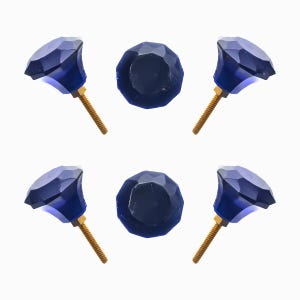 May include: Six faceted, dark blue cabinet knobs with brass-colored screws. The knobs are arranged in a circular pattern against a white background. The knobs have a jewel-like appearance.