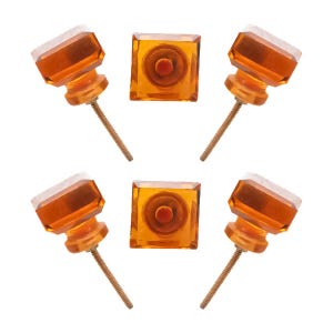 May include: Six amber-colored cabinet knobs with a square or octagonal shape. The knobs have a clear, faceted top and a brass screw. The knobs are arranged in a circular pattern against a white background.