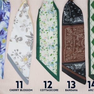 Five colorful fabric scarves with different designs. One is blue with a iris flower pattern, another is beige with cherry blossoms, a third is green and white in floral cottagecore style, the fourth has is in classic bandana pattern with brown and black colors. The last has green argyle pattern. Each scarf has a number and a descriptive word.