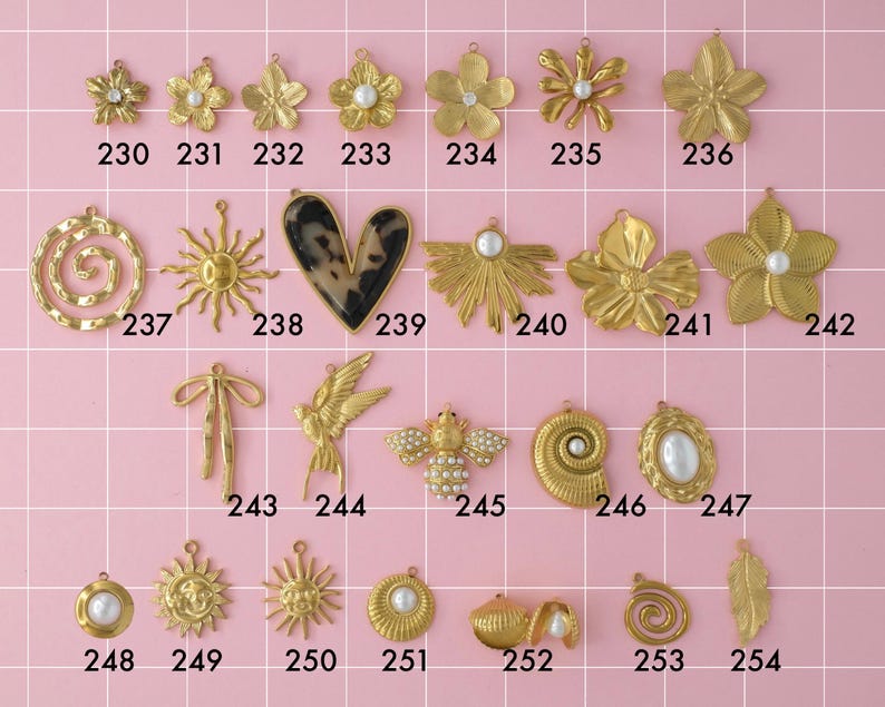 A collection of gold plated stainless steel big charms. Charms include flowers, hearts, geometric shapes, and pearls. Charms are laid out on a pink background with identifying numbers.