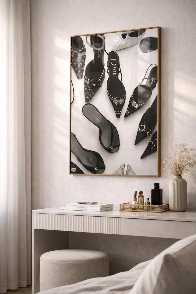 Puede incluir: Impresi&oacute;n en blanco y negro enmarcada con varios zapatos de tac&oacute;n alto. Los zapatos incluyen zapatos de sal&oacute;n, sandalias y slingbacks, algunos con adornos. La impresi&oacute;n se muestra sobre una c&oacute;moda con una bandeja dorada que contiene frascos de perfume y un jarr&oacute;n con flores secas.