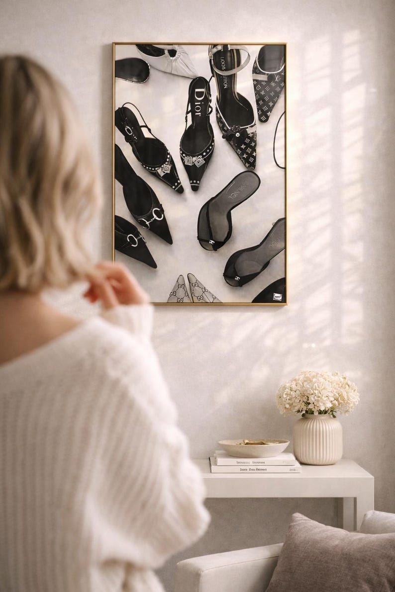 Puede incluir: Una impresi&oacute;n enmarcada que presenta una variedad de zapatos de mujer, incluyendo tacones altos y sandalias, en varios estilos y colores. Los zapatos est&aacute;n dispuestos sobre un fondo blanco, con un marco dorado. La impresi&oacute;n se exhibe en una pared.