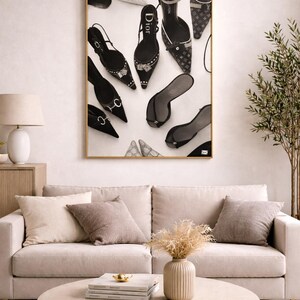 Puede incluir: Una impresi&oacute;n enmarcada con una colecci&oacute;n de zapatos de tac&oacute;n alto en blanco y negro, incluyendo dise&ntilde;os de Dior y Louis Vuitton. Los zapatos est&aacute;n dispuestos sobre un fondo blanco, creando una declaraci&oacute;n de moda elegante.