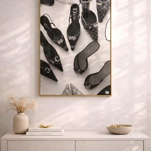 Puede incluir: Una impresi&oacute;n enmarcada que presenta una colecci&oacute;n de zapatos de tac&oacute;n alto, sandalias y zapatos de sal&oacute;n negros. Los zapatos est&aacute;n dispuestos sobre un fondo blanco, con un marco dorado. La imagen incluye varios estilos y dise&ntilde;os de calzado.