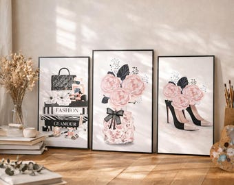 Puede incluir: Tres impresiones artísticas enmarcadas con ilustraciones de moda. Una muestra un bolso, perfume y libros con texto "Fashion" y "Glamour". Otra representa flores rosas en un jarrón decorativo. La tercera muestra zapatos de tacón alto.