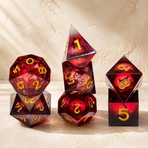 Può includere: Un set di sei dadi poliedrici rossi, tra cui un d20, d10 e d4. I dadi hanno numeri dorati e sono fatti di un materiale traslucido. Adatto per giochi di ruolo e altri giochi di dadi.