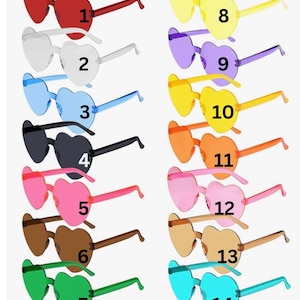 May include: Collection of heart-shaped sunglasses in various colors, including red, white, blue, black, pink, brown, green, yellow, purple, and orange. Each pair has matching colored frames. The sunglasses are numbered 1 through 14.