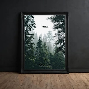 May include: Framed art print featuring a misty forest scene with tall evergreen trees. The word "forks" is printed in white at the top. The phrase "inspired by the Twilight Saga" is printed at the bottom. The frame is black.