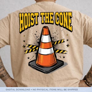 Puede incluir: Camiseta color beige con un gr&aacute;fico de un cono de tr&aacute;fico naranja y blanco sobre una base negra, con las palabras "HOIST THE CONE" en amarillo y negro. El dise&ntilde;o incluye estrellas negras y cinta de precauci&oacute;n amarilla y negra.