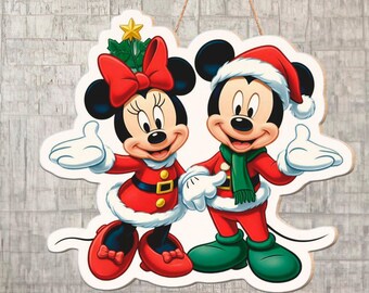 Könnte beinhalten: Weihnachtsdekoration aus Holz mit Mickey und Minnie Mouse in festlicher Kleidung. Mickey trägt einen Weihnachtsmannhut und einen grünen Schal, während Minnie eine Schleife und ein Kleid hat. Beide tragen rot-weiße Outfits mit offenen Armen.