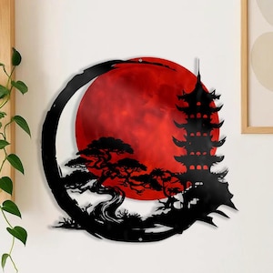 May include: Black metal wall art featuring a Japanese pagoda, a stylized tree, and a red moon within a black circular frame. The artwork is mounted on a white wall, creating a striking contrast. The design evokes a sense of tranquility and cultural appreciation.