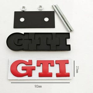 May include: A set of black and red GTI car emblems. The red GTI emblem is 9.2cm long and 2.3cm high. The black emblem is in the shape of the GTI letters. Includes mounting hardware.