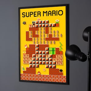 Könnte beinhalten: Gerahmtes Poster mit einem Pixel-Art-Design eines Super Mario-Levels auf gelbem Hintergrund. Der Text "SUPER MARIO" steht oben, mit Ziegeln, Münzen und Feinden. Das Poster hängt an einer grauen Wand, mit einer schwarzen Lampe.