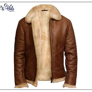 Puede incluir: Chaqueta de cuero marrón con forro y cuello de borrego color crema. La chaqueta tiene cierre de cremallera y un estilo aviador clásico. La marca "Jack & Hide" es visible en la esquina superior izquierda.